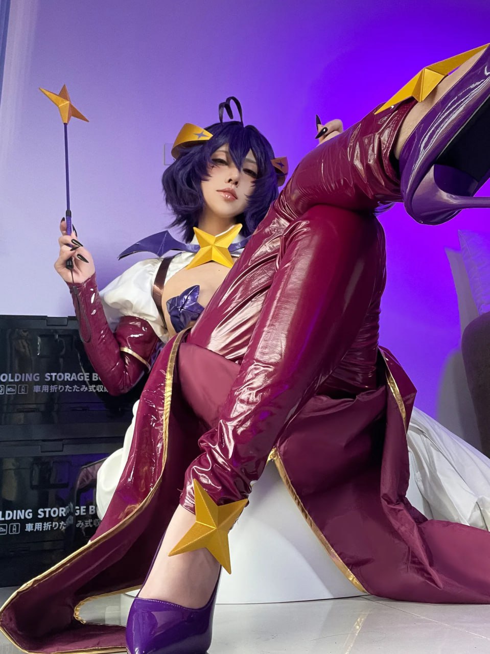 Alluring Cosplay Sorceress in Maroon and Purple Attire Alluring Cosplay Sorceress in Shiny Maroon and Purple Attire Posing Seductively with Magic Wand